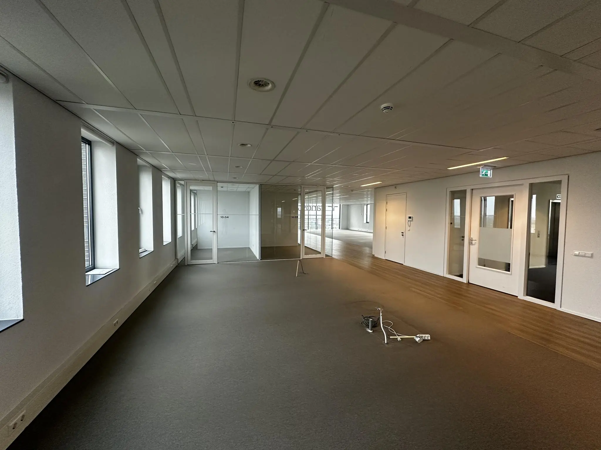 Leeg kantoorpand aan de Laan van Zuid Hoorn met glazen vergaderruimtes en vloerbekabeling.